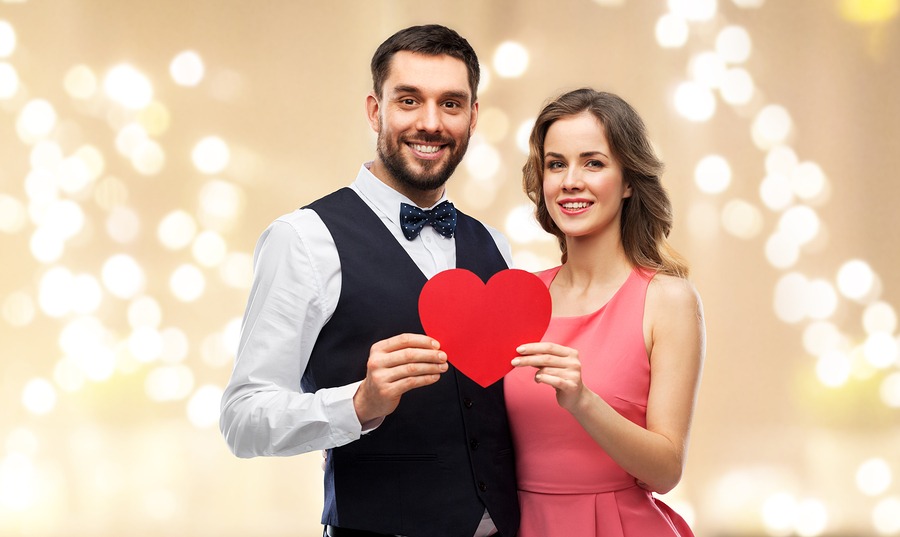 young couple holding a paper heart