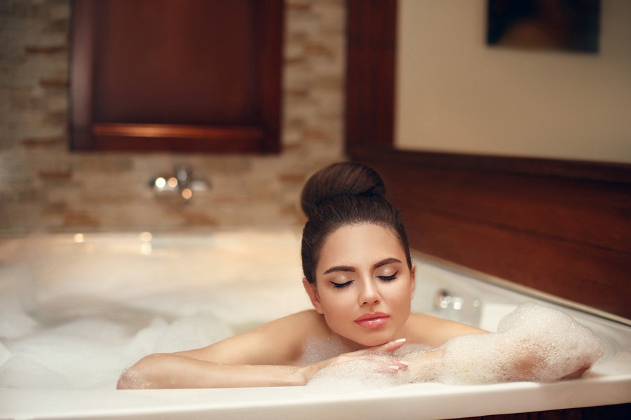 young woman relaxing in jacuzzi bath spa