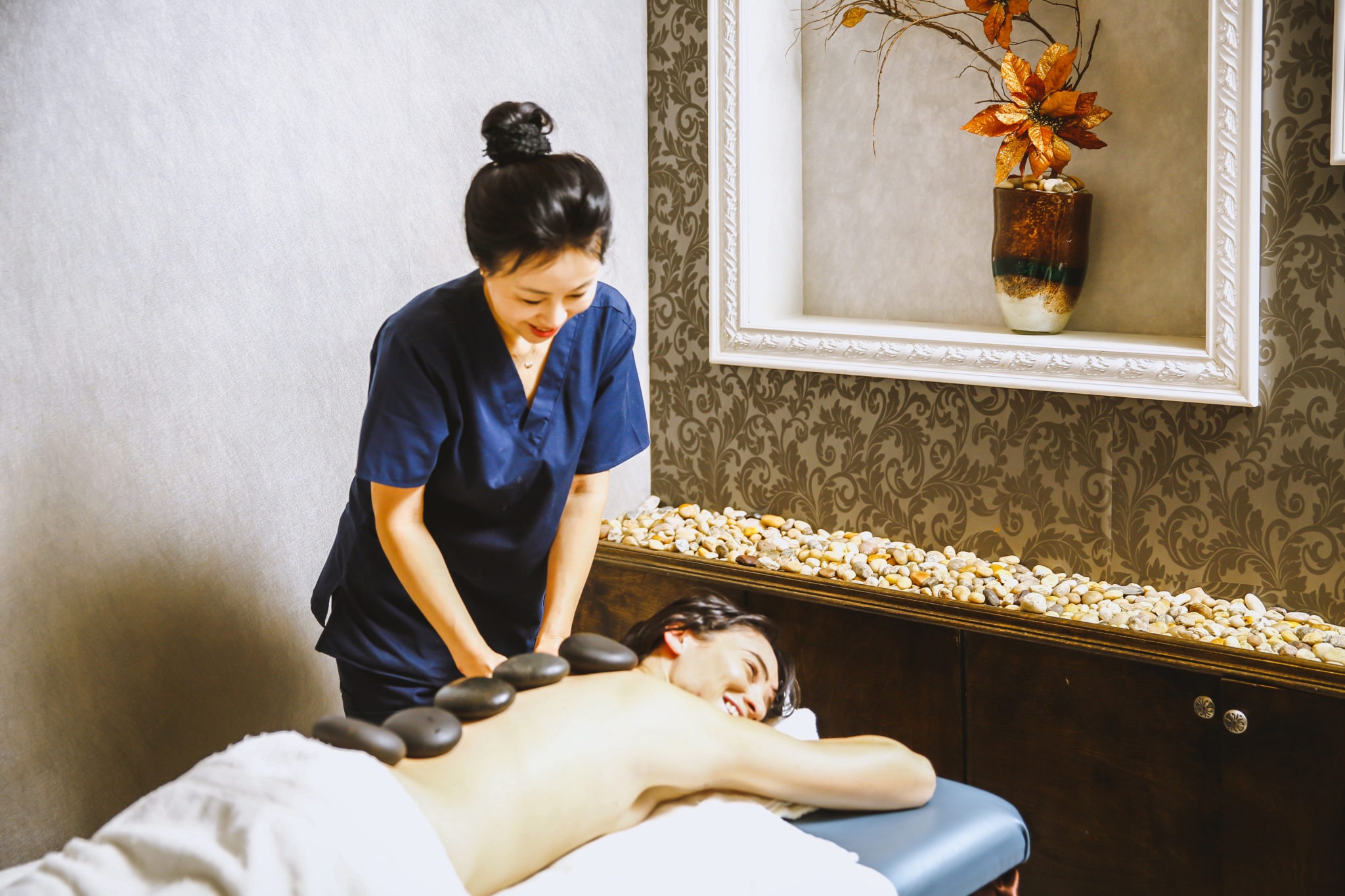 asian woman giving a hot stone massage