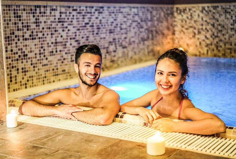 Happy couple having fun in swimming pool luxury spa in New York City – Romantic young people doing relaxing wellness treatment together – in Juvenex Spa Manhattan