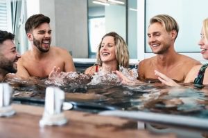 Happy friends enjoying vacations in jacuzzi luxury spa massage - Young people having fun together in hot tub - New Year's Vacation Deals Top Getaway valentine gift card for wife valentines ideas for her in New York City